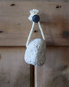 A natural off white pumice stone on a rope
