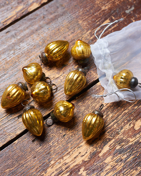 Decorative Christmas baubles hanging on branches against a blurred background