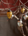 Decorative glass orbs hanging from branches against a blurred background