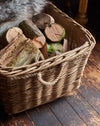 Wicker basket filled with logs on a wooden floor