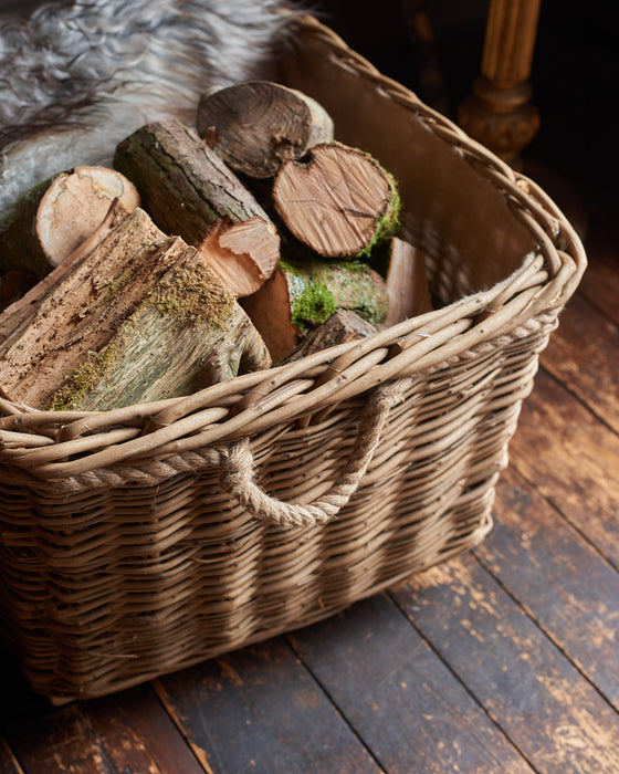 Wicker basket filled with logs on a wooden floor