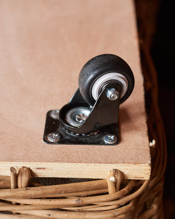Close-up of a wooden cart with a wheel and metal bracket.