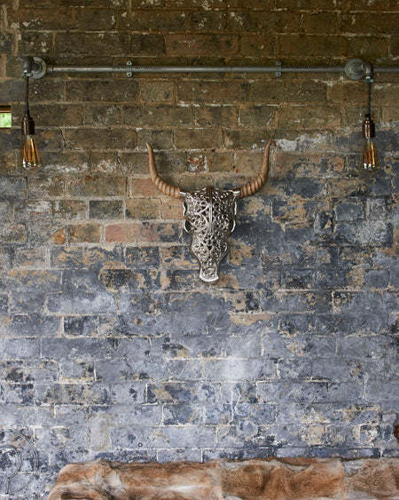 Decorative silver faux bull skull with carved wooden horns.