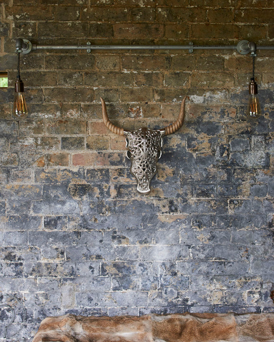 Decorative silver faux bull skull with carved wooden horns.