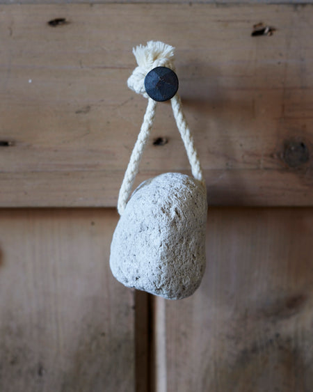 A natural off white pumice stone on a rope