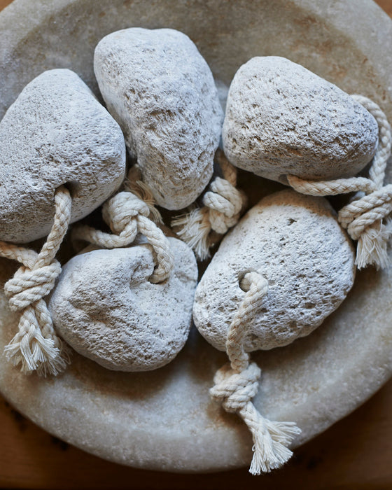 A natural off white pumice stone on a rope