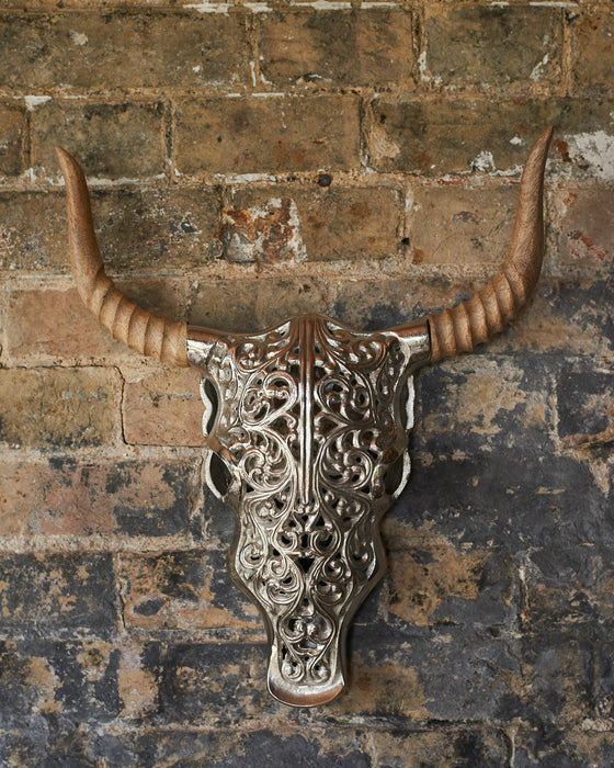Decorative silver faux bull skull with carved wooden horns.