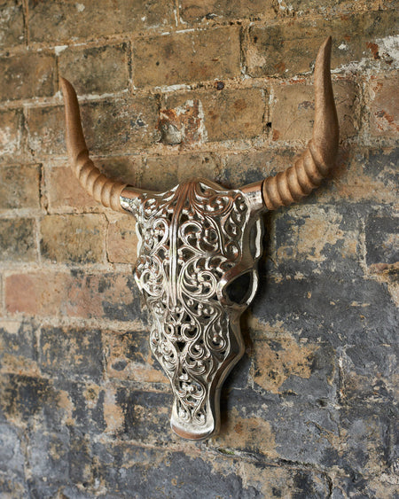 Decorative silver faux bull skull with carved wooden horns.
